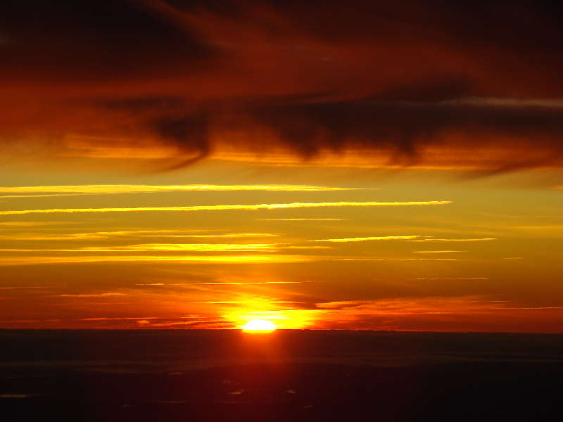 Sonnenaufgang zwischen Wolken im Flug ber Oslo