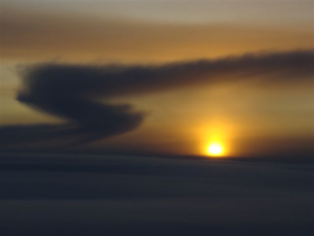 Wolkenschichten mit S-Form bei Sonnenuntergang